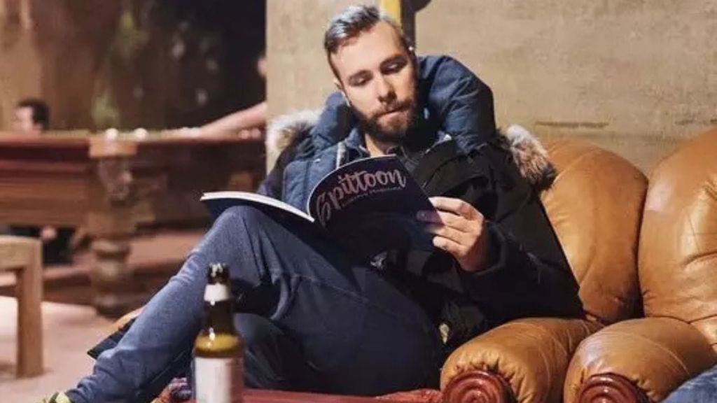 Man reads Spittoon Magazine